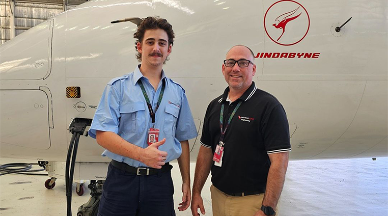 Father and son engineers smiling at camera