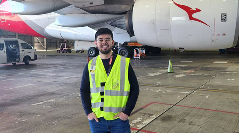 Qantas employee in the hangar, smiling at camera