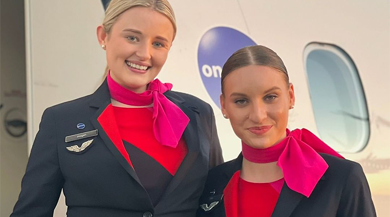 2 QantasLink cabin crew members smiling at camera