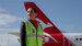 Customer Service Agent wearing high-vis uniform on tarmac in front of a Qantas aircraft